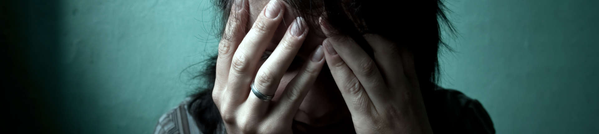 Female domestic violence victim hiding her face in hands