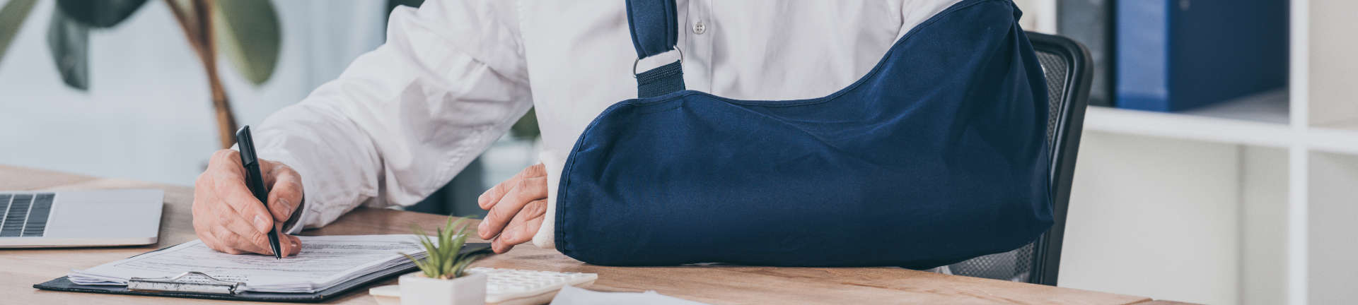 Person with a broken arm at a lawyer's office filling out documents to claim Workers' Compensation