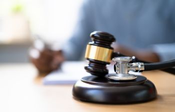 A stethoscope and a gavel on a medical malpractice lawyer's desk.